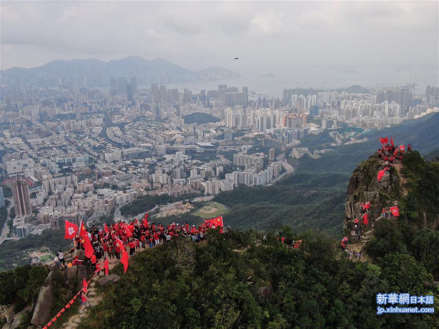 （社会）（2）百余名香港市民爬上狮子山顶挥舞国旗、区旗