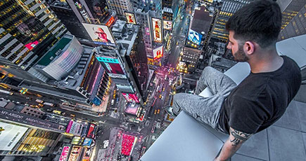 米男性、60階建てビルの屋上の淵を歩き街を撮影