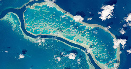 宇宙からサンゴ礁を見下ろす、海水の色の差が対照的