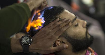 パレスチナの理容師は火でストレートパーマ