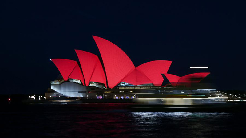 オペラハウス、中国紅にライトアップ　シドニー